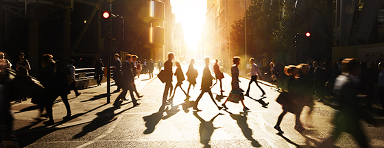 People walking in the city with sun behind them