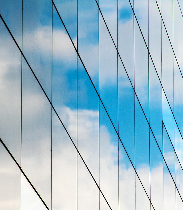 Reflection of cloudy sky in glass building facade