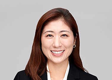 A professional woman smiling into a photo with a blank background