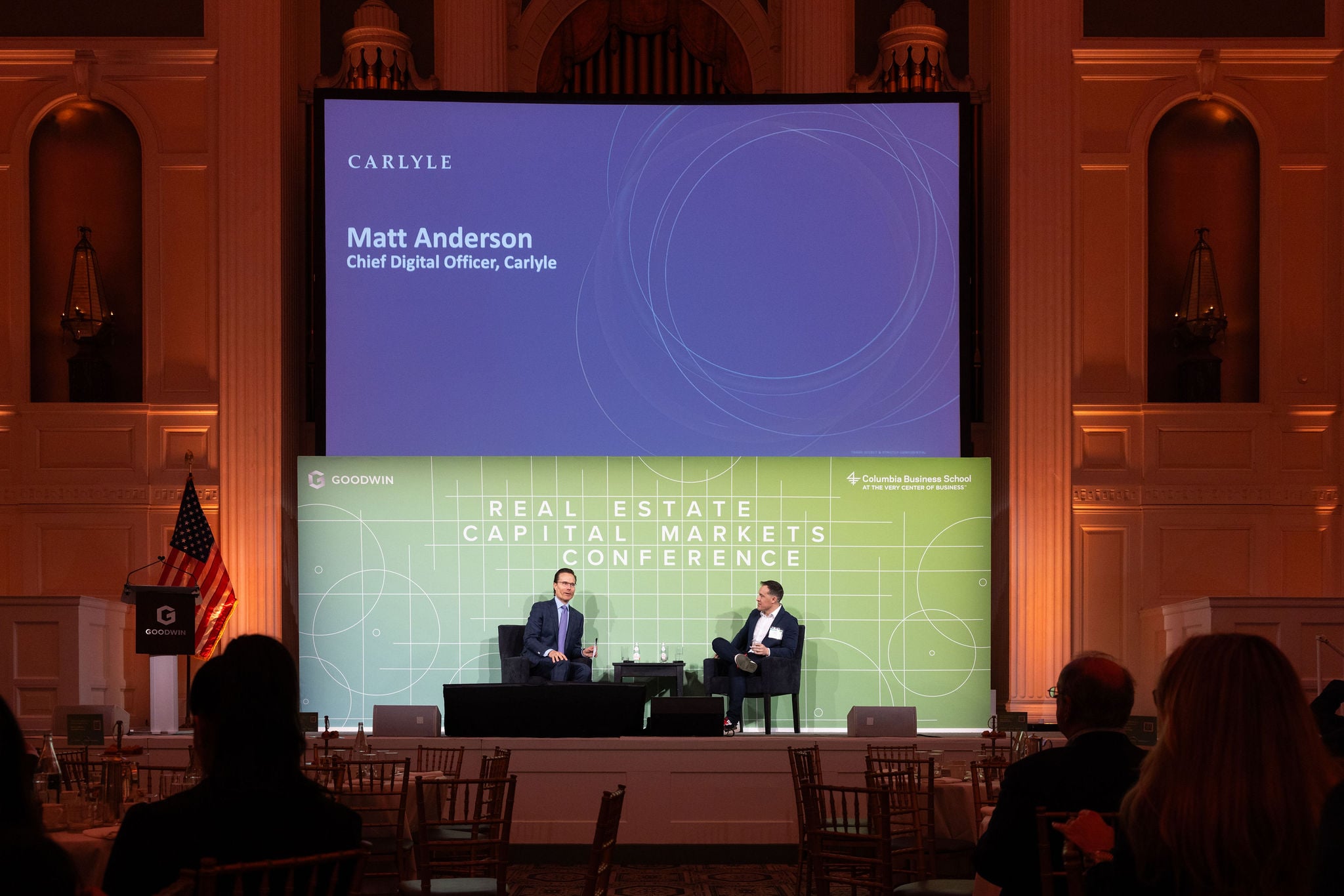 Two speakers on stage in a fireside chat at the Goodwin and Columbia Business School Real Estate Capital Markets Conference.