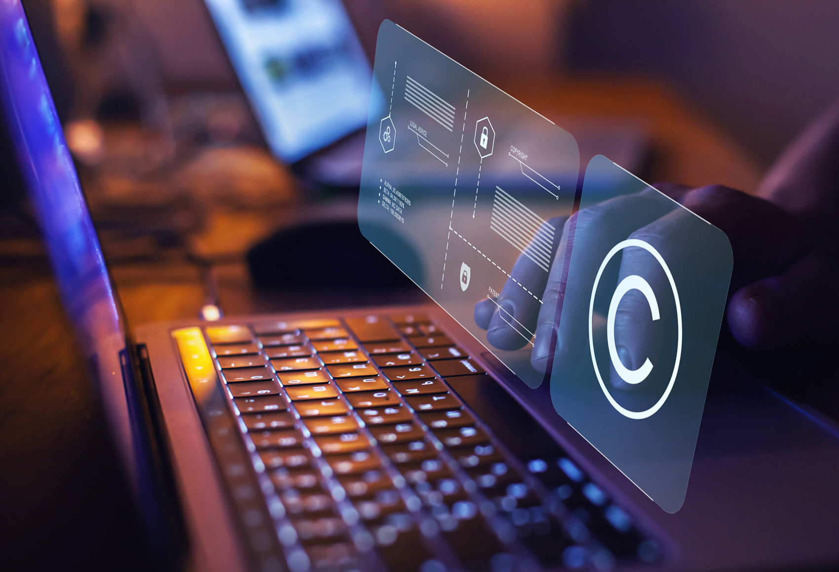 A mans hand resting on a laptop with an augmented display showing in front of him