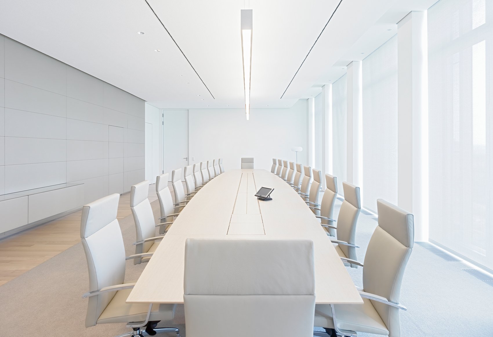 An all white conference room with empty chairs