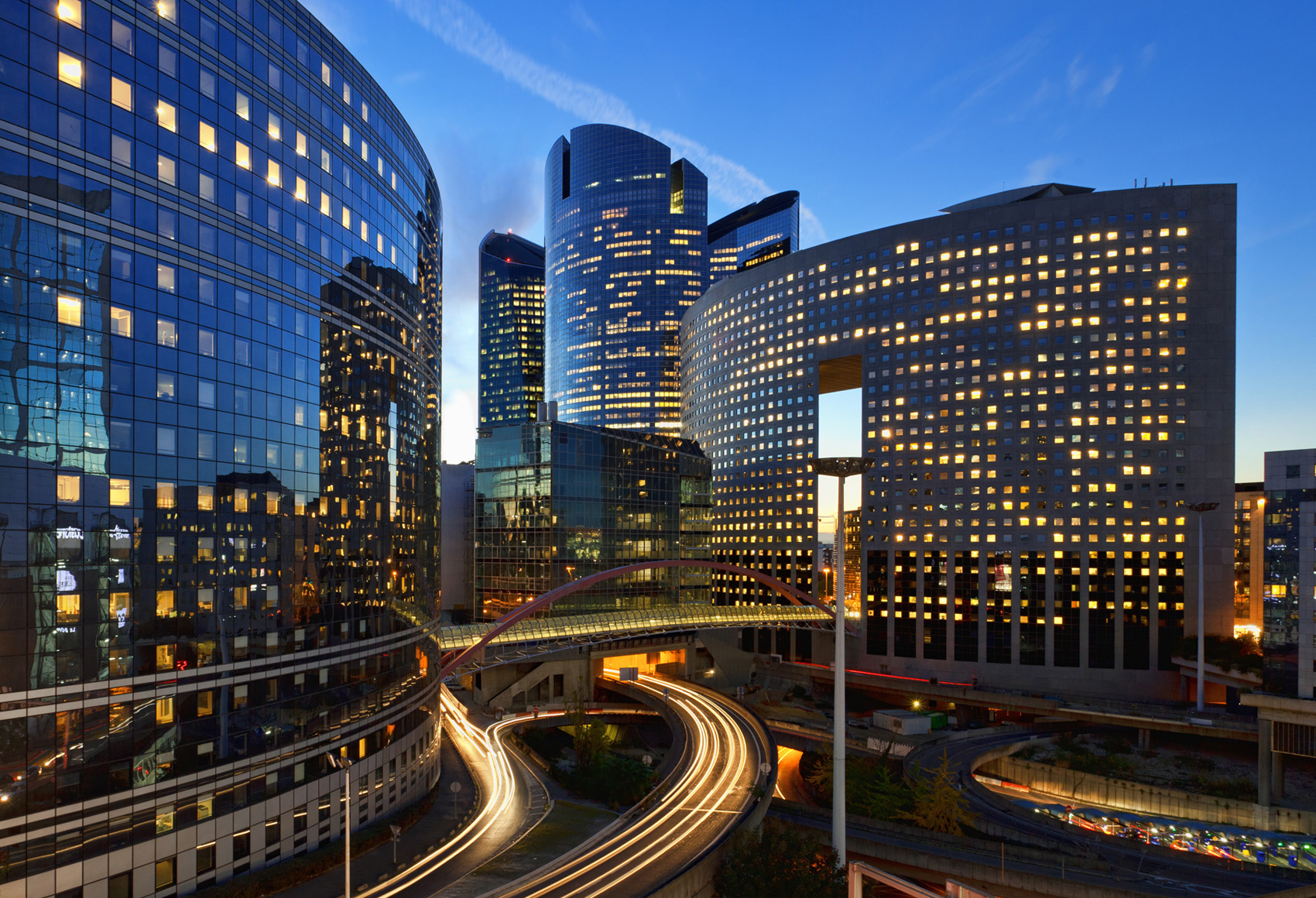 A shot of a few curved glass Highrise buildings during a sunset