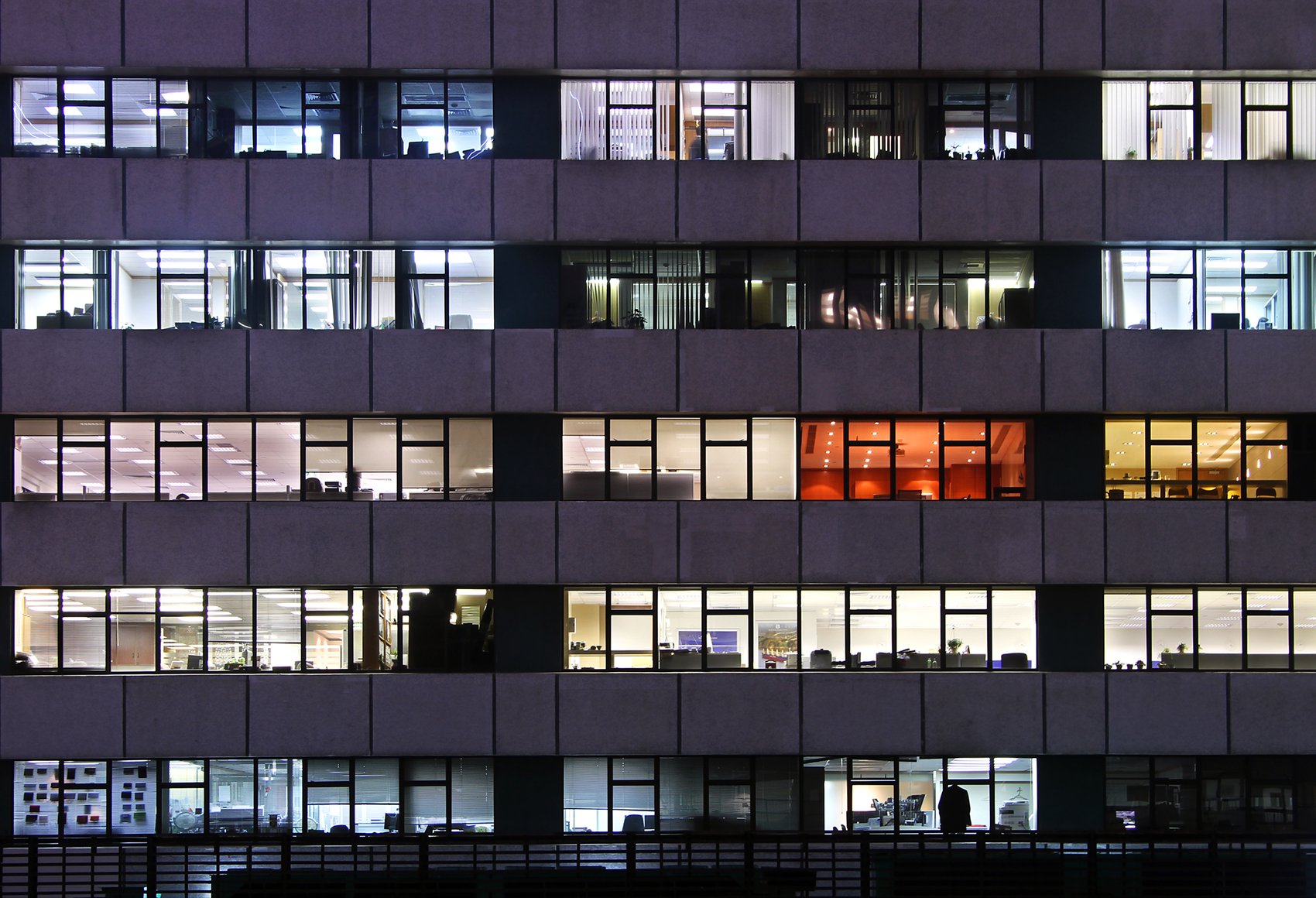 A night-time image looking into windows of an office building