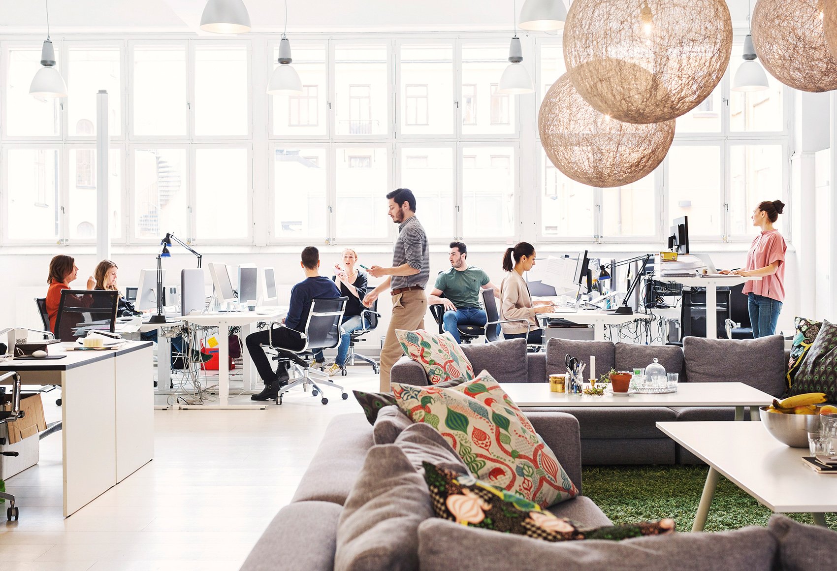 A corporate indoor working space with a team of people discussing with one another